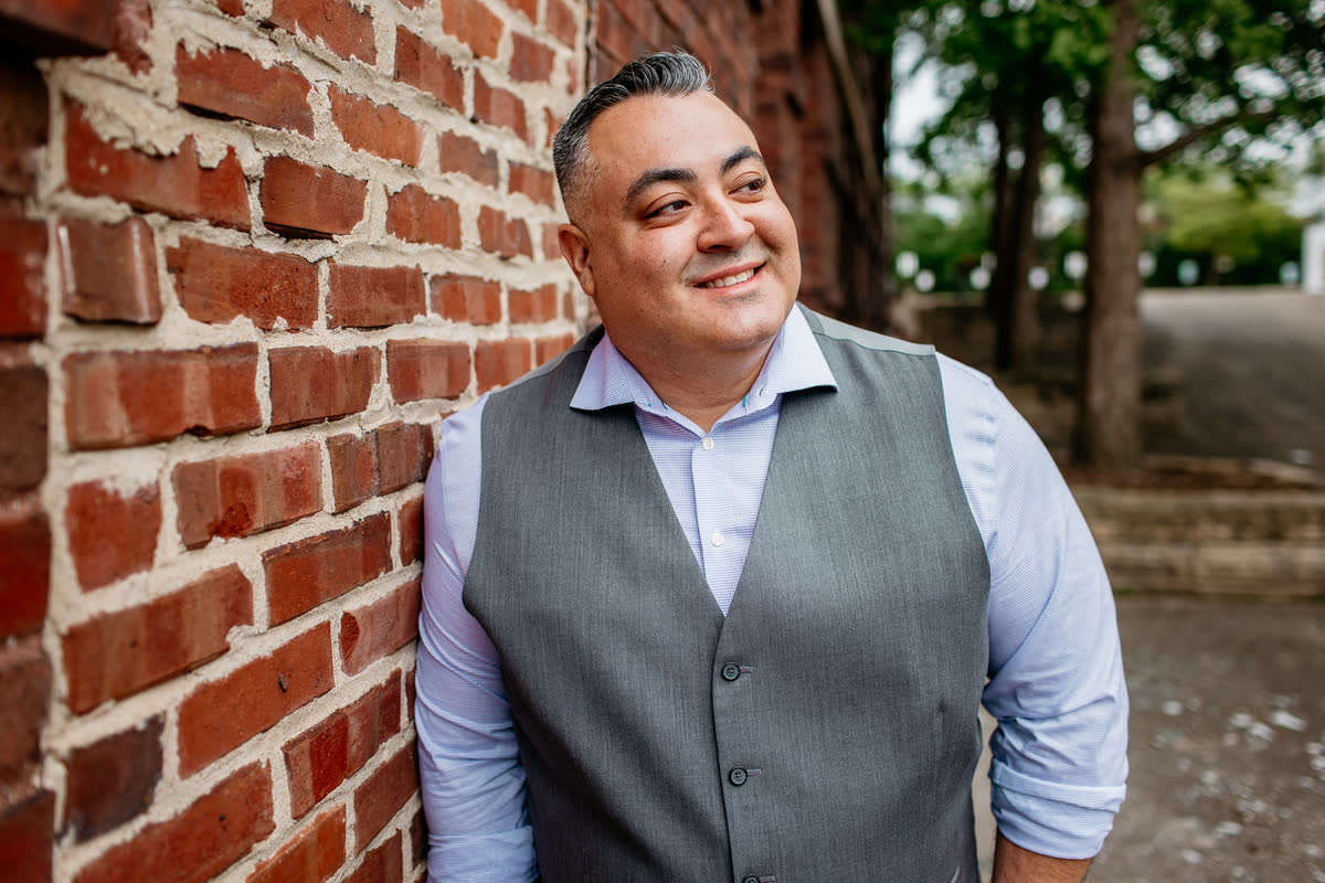 Eddie Valdes, President of Strong Tower Advisors, standing by a brick wall